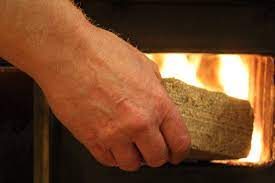 Loading night briquette into stove