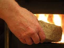 Loading night briquette into stove