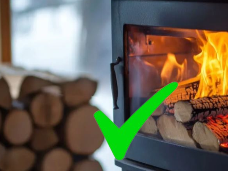 A cosy wood-burning stove with flames and logs in the background.